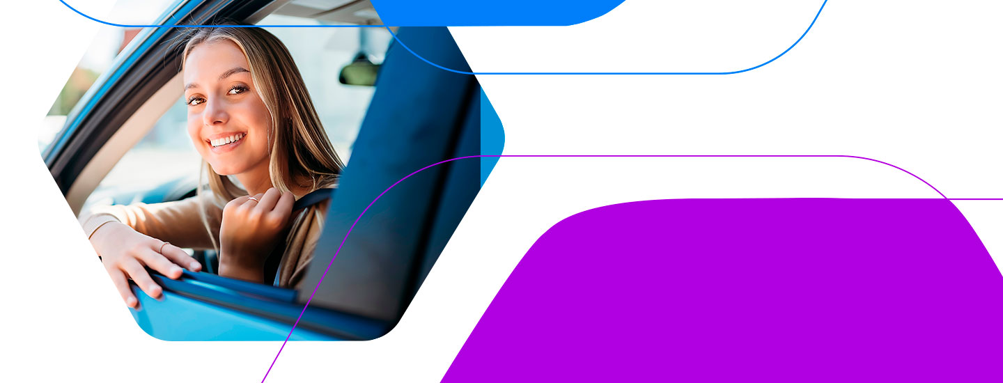 Foto de uma mulher jovem sorrindo, olhando pela janela do carro que est digirindo