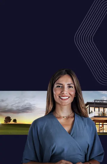 Foto de mulher sorrindo em primeiro plano e manso com amplo terreno ao fundo.