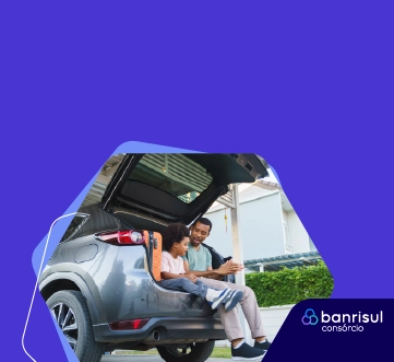 imagem de pai e filho sentados em porta-malas de carro aberto conversando